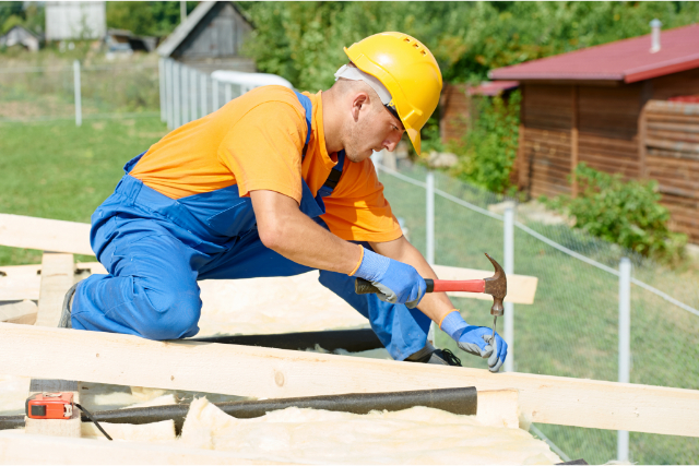 Carpenter Works on Re-Roofing a home
